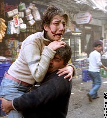 An injured woman is carried away from the British Consulate blast site in Istanbul on Thursday.