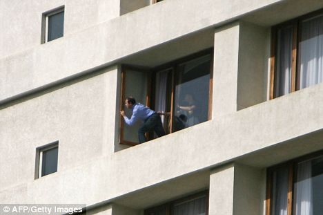 Desperate: A hostage at the Oberoi peeks out of his window as the siege continues