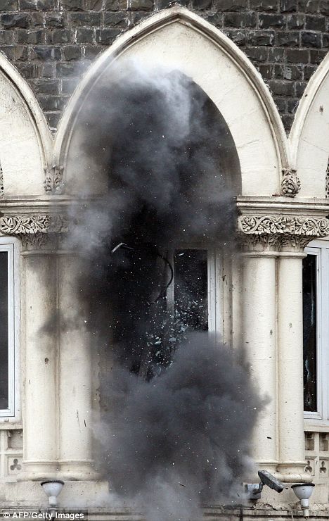 Blast: Police throw a grenade into the Taj Mahal hotel as they desperately try to control a militant believed to be holed up in a ballroom inside